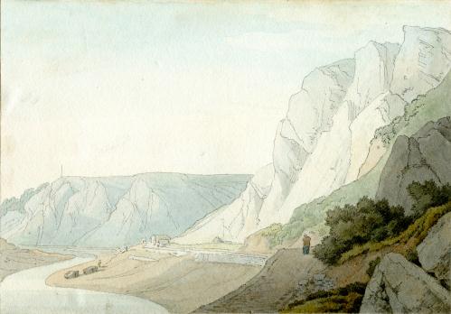 Mountains next to small hills and river with one figure on cliff