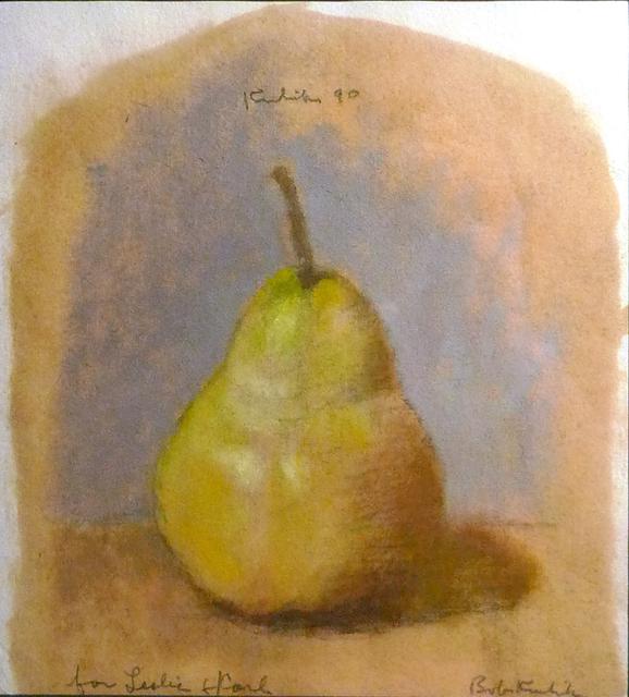 Green pear on brown table in front of blue wall on tan paper