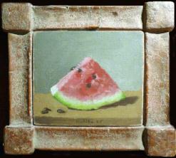 Wedge of watermelon with three seeds at lower left on table in geometrric frame