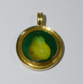 Bright green pear in green circle in gold pendant on white table