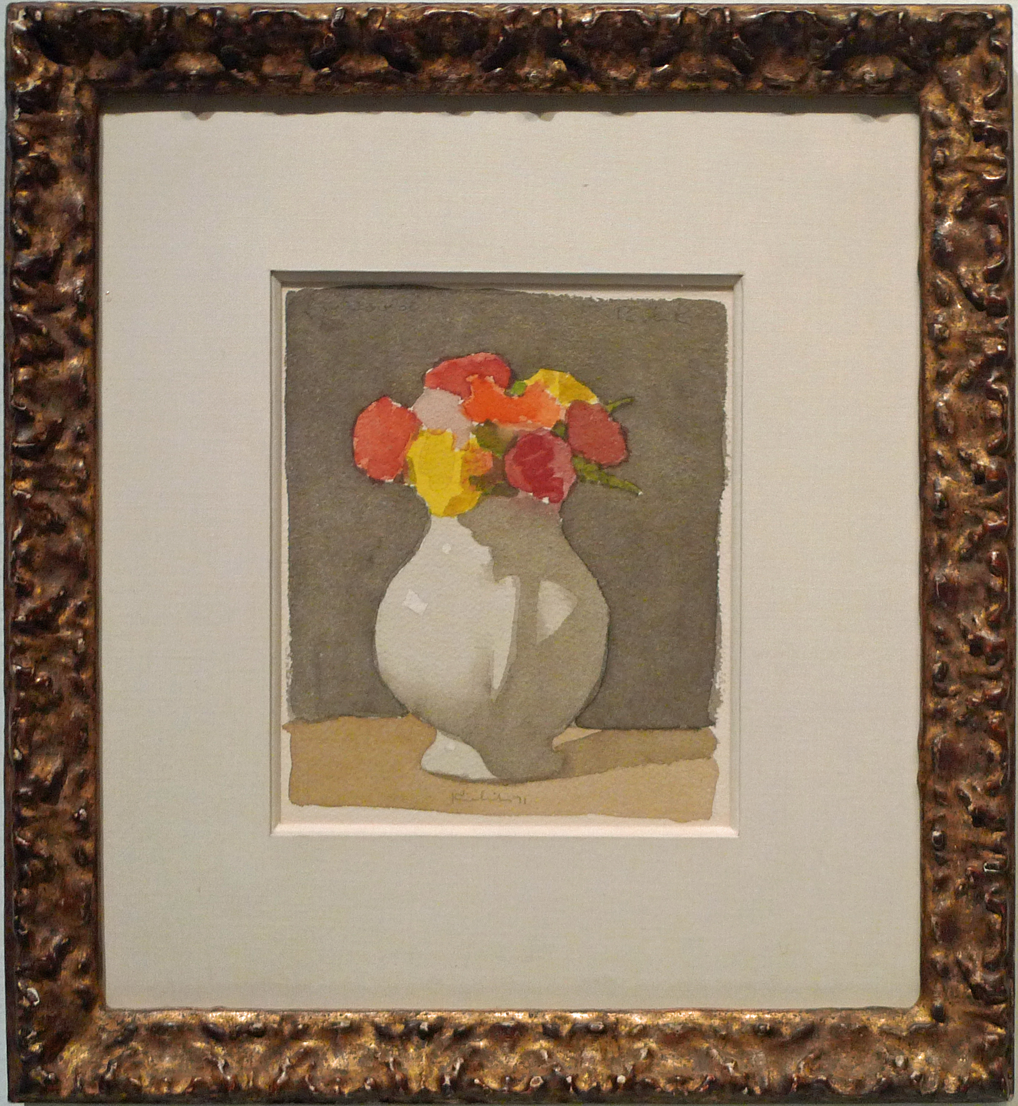 Boquet of red, orange, and yellow flowers in white vase on table in gold frame