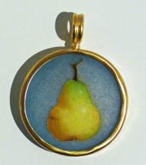 Green pear with in blue circle in gold pendant on white ground