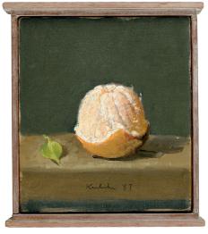 Orange peeled three quarters from top to bottom with green leaf at left on brown table in front of grey wall in wood frame