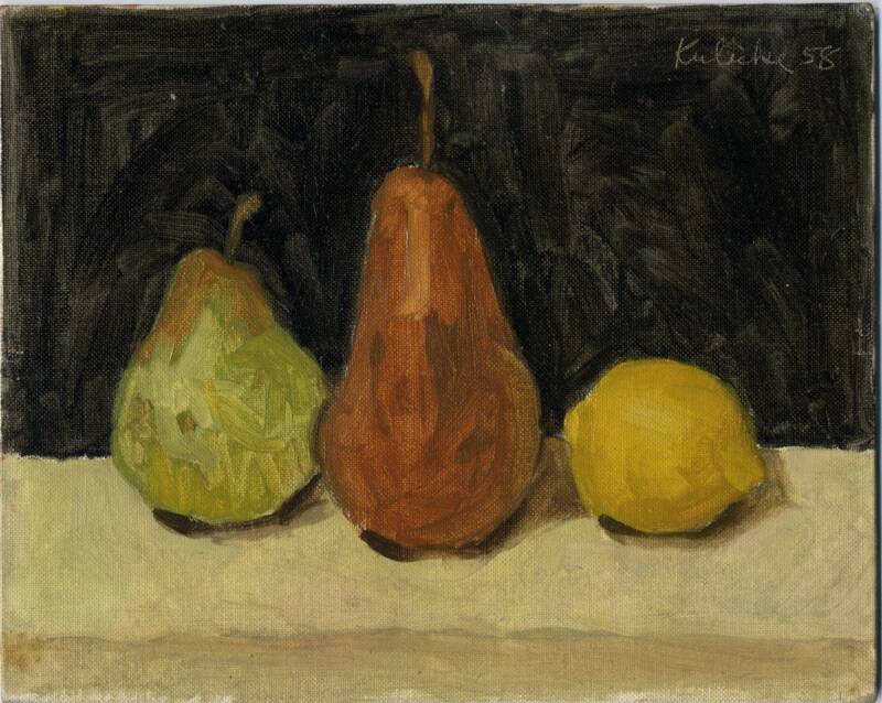 Green pear and brown pear with lemon on tan table in front of black wall