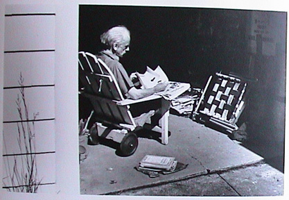 Seated man holding book inside garage