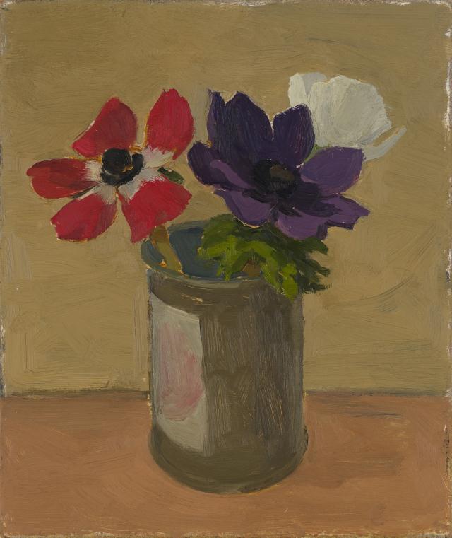 Red, purple, and white flowers in grey tin on brown table