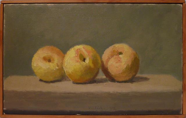 Three peaches on brown table in front of grey wall