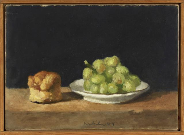Scone and green grapes on brown table with black background