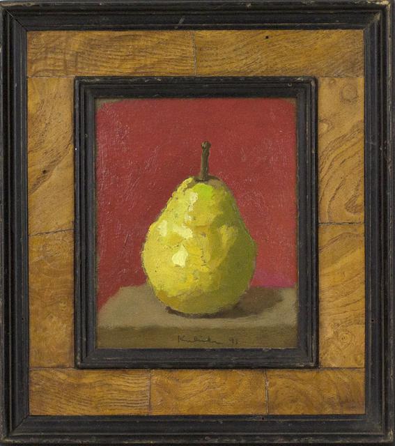Green pear on brown table in front of red wall in black and wood frame