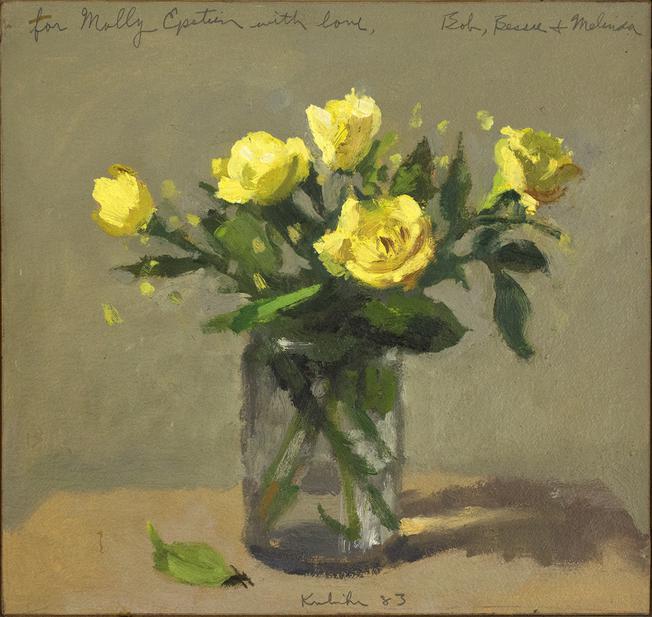 Five yellow roses in glass jar on brown table in front of grey wall