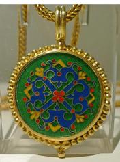 Green enamel pendant with blue, yellow, and red decoration in granulated pendant