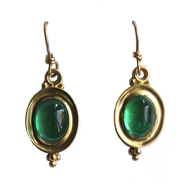 Emerald green earrings set in gold on white background