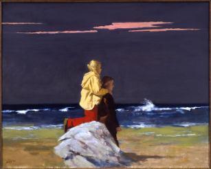 Beach scene with one child in yellow jacket standing on a rock and leaning her hands on the shoulders of another figure