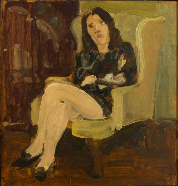 Woman with dark hair sitting in yellow armchair with legs crossed