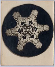 Snowflake with six blunted points on black circle