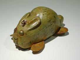 Yellow green rabbit with flat ears and metal feet facing left