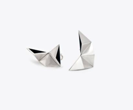 Two silver earrings made of trangular geometric shapes at center of white background
