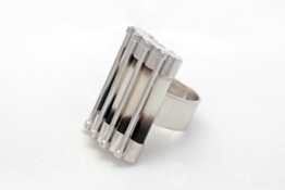 Silver and porcupine ring resting on its side on white background
