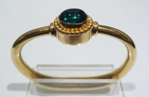 Gold bracelet with green gem in granulated setting