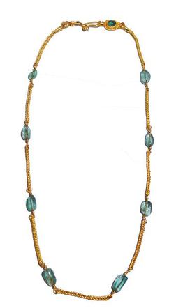 Light blue beads connected by gold chain segment necklace, clasped, and laid flat