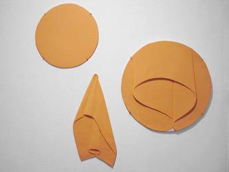 Three orange circles: top left circle, more detailed circle at right and draped cloth at bottom