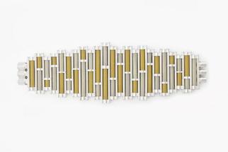 Silver bracelet stretched out flat composed of alternating ochre and white cylindrical tubes