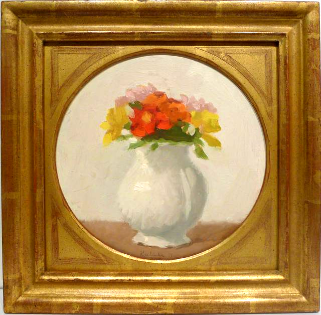 Orange, yellow, and pink flowers in white vase in circle in gold frame