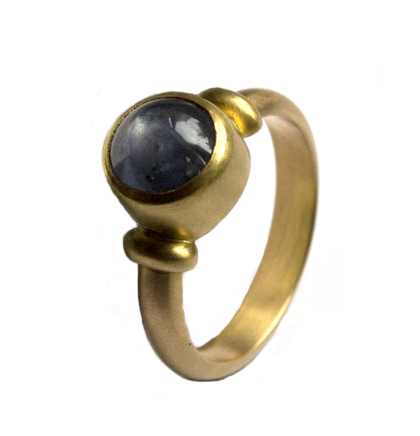 Blue grey sapphire ring in three quarter profile on white background